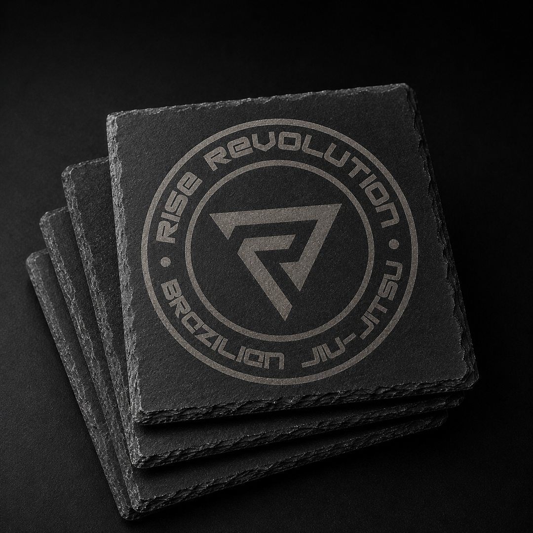 Stack of four 4 inch square natural slate coasters laser engraved with the full Rise Revolution badge